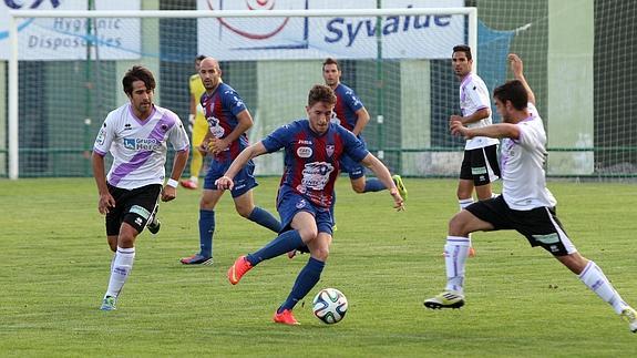 Miguel Herranz controla el balón entre dos rivales. 