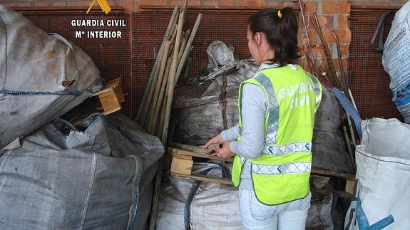 Una agente de la Guardia Civil examina los objetos intervenidos en la 'Operación Palrayo'. 