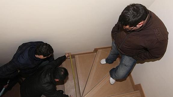 Tres cooperativistas miden la escalera primitiva, en la Ciudad de la Juventud. EL NORTE