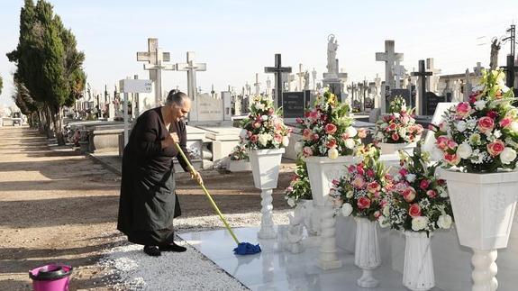 Una mujer friega un panteón en el cementerio de El Carmen. 
