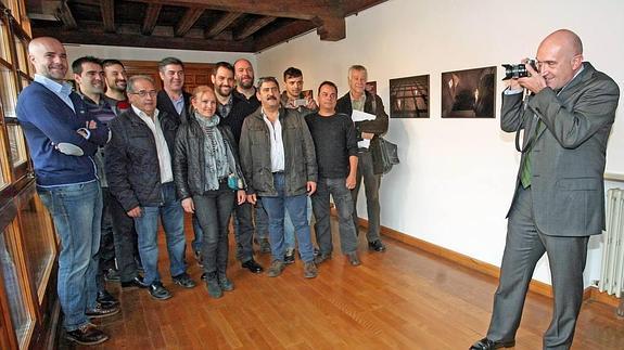 El presidente, Jesús Julio Carnero, fotografía a los autores, rodeados de las imágenes de la muestra ‘Mirada del Alma’, en el claustro del Palacio de Pimentel 