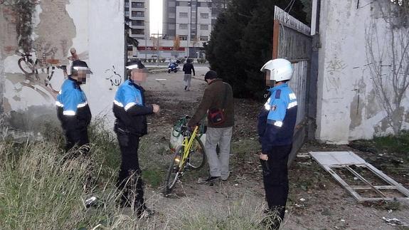Dos hombres abandonan el cuartel de Artillería ante la atenta mirada de los policías locales. 