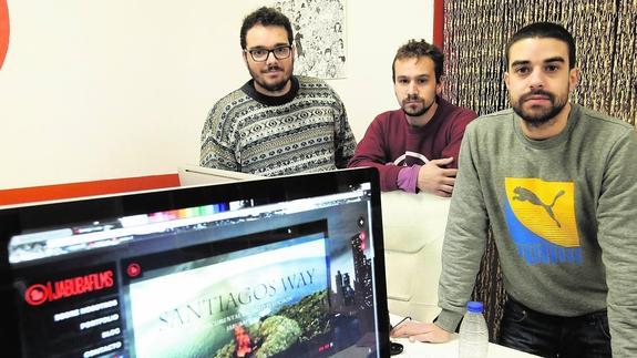 Parte del equipo de Jabuba Films en la sede de su empresa frente a la portada de su documental sobre el Camino de Santiago.