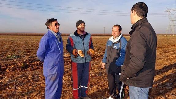 García muestra las patatas a algunas de las personas que se acercaron a recogerlas. 