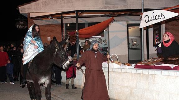 Los vecinos que encarnaron a la Virgen María, a lomos de un burro, y San José desfilan por una calle de la localidad. 