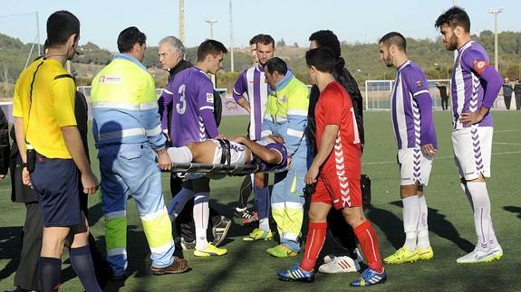 Los médicos retiran en camilla al accidentado Ángel, ante la mirada de sus compañeros.