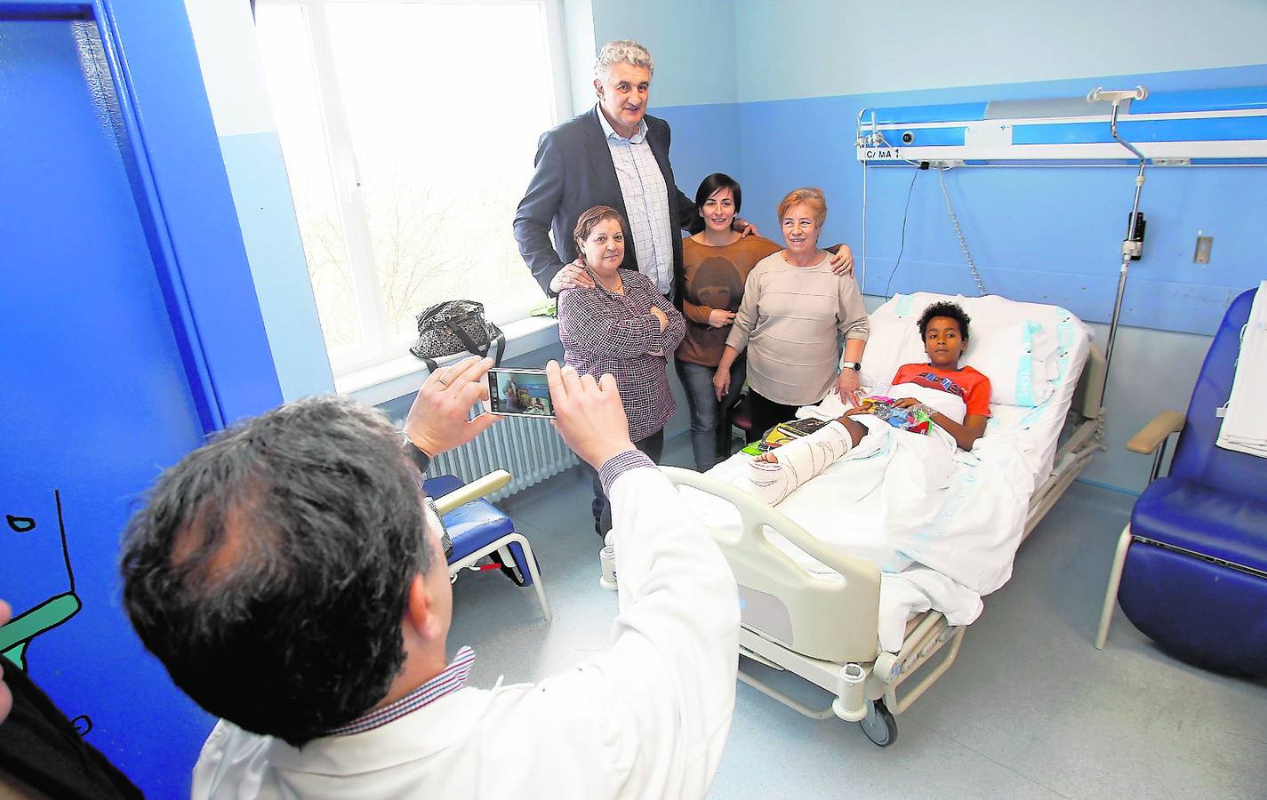 El gerente del Complejo Hospitalario de Palencia, José Jolín, fotografía con un móvil a Romay con Kenai, un niño de 11 años, y su familia.