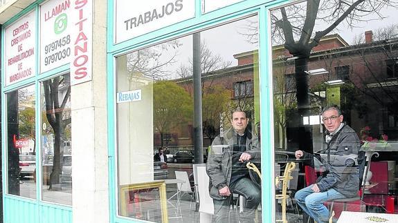 Álex Blell y Ovidio Bonet, sentados en una mesa entre los muebles que venden en la tienda de Casado del Alisal. 