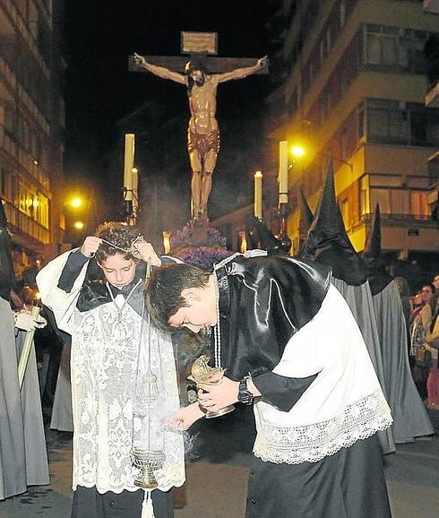 Dos jóvenes cofrades preparan los incensarios. 