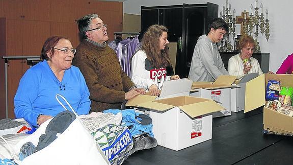 Hermanos de la cofradía de Jesús de Medinaceli ordenan la ropa y los alimentos recogidos para entregarlos en breve. El segundo por la izquierda, el hermano mayor, Luis Casalduero Gil. 