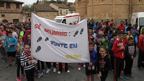 Un grupo de niños muestra una pancarta en la que se anima a la participación. 