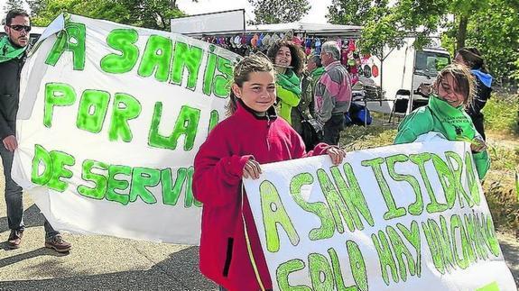 Vecinos de Dueñas portan pancartas en la romería del pasado año para reivindicar una vía de servicio en la Autovía de Castilla.