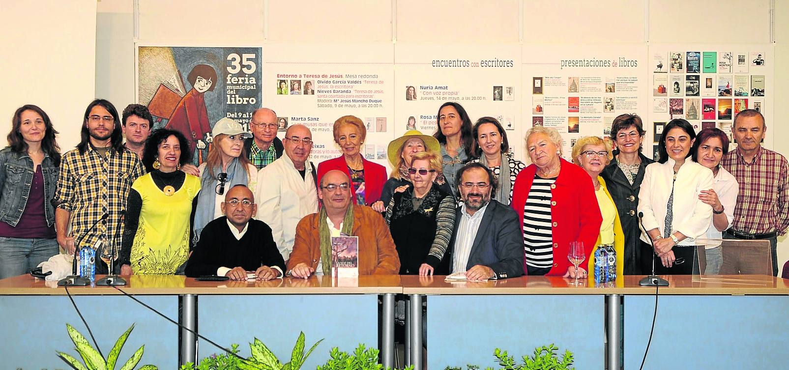 Muñoz Quirós, junto a su libro, rodeado de participantes en la presentación del libro. 