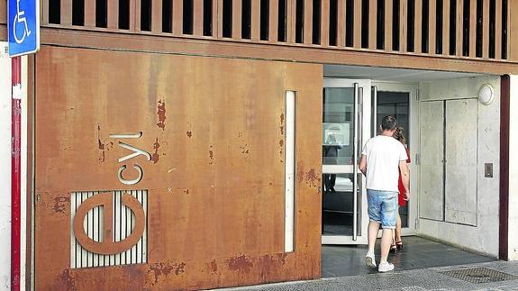 Dos jóvenes entran en la oficina del Ecyl situada en la calle de Las Monjas de la capital palentina.