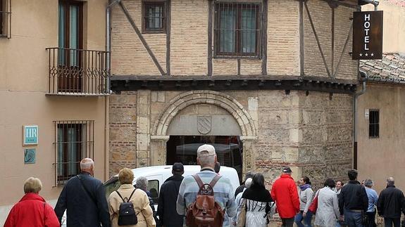 Turistas pasan por delante de la entrada del hotel Exe Casa de Los Linajes, recientemente reabierto en Segovia.