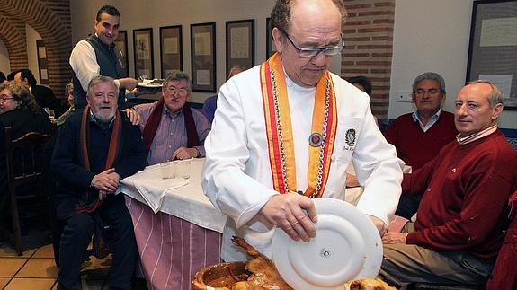El restaurador José María Ruiz realiza el ritual de partir el cochinillo 