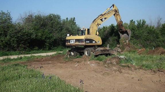 Una excavadora trabaja ya en remover la tierra para las obras del colector. 