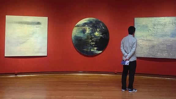 Un visitante admira algunas de las obras expuestas por Alberto Reguera en Hong Kong.