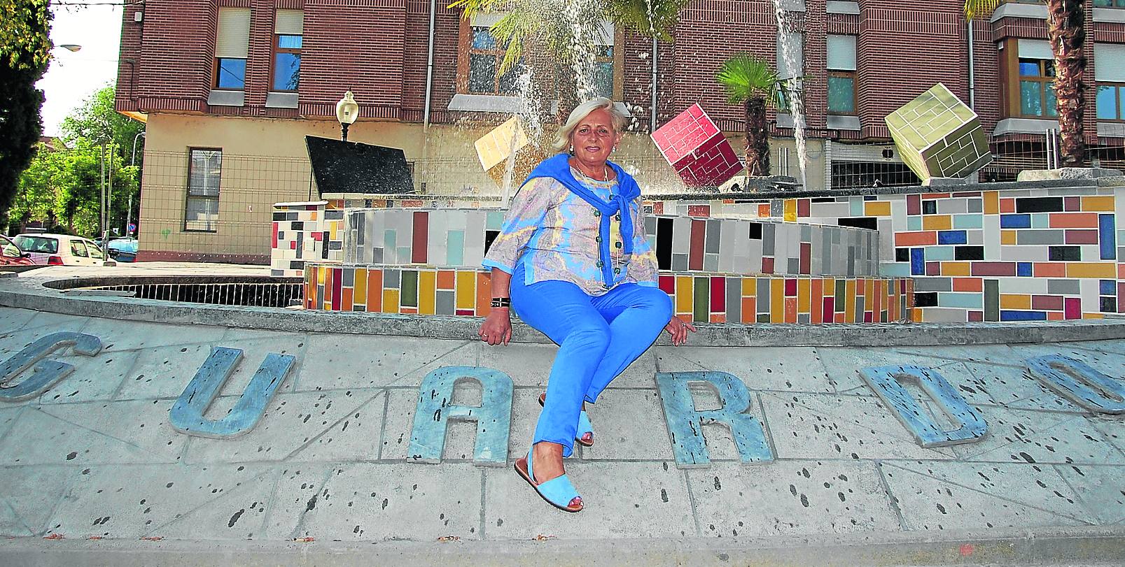 Lali Pinilla, sentada en la nueva fuente de la plaza de la Constitución de Guardo.
