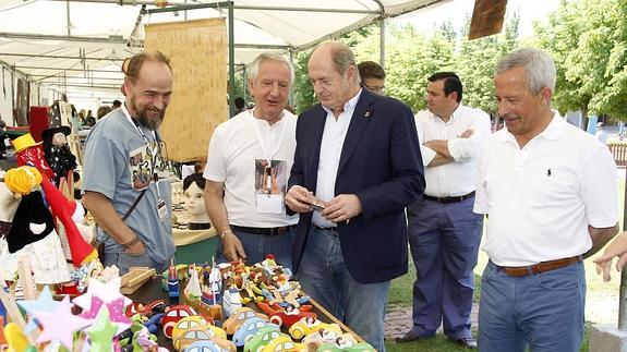 Minguela, en el centro, charla con dos artesanos en presencia de Román Rodríguez, a la derecha, durante la inauguración de la Feria Artelago el pasado fin de semana.