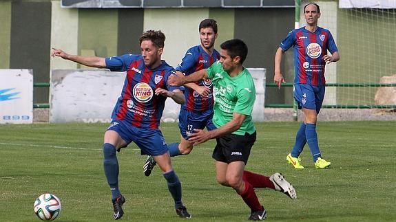 Miguel Herranz protege el balón ante un jugador del Laredo durante el partido de ida. 