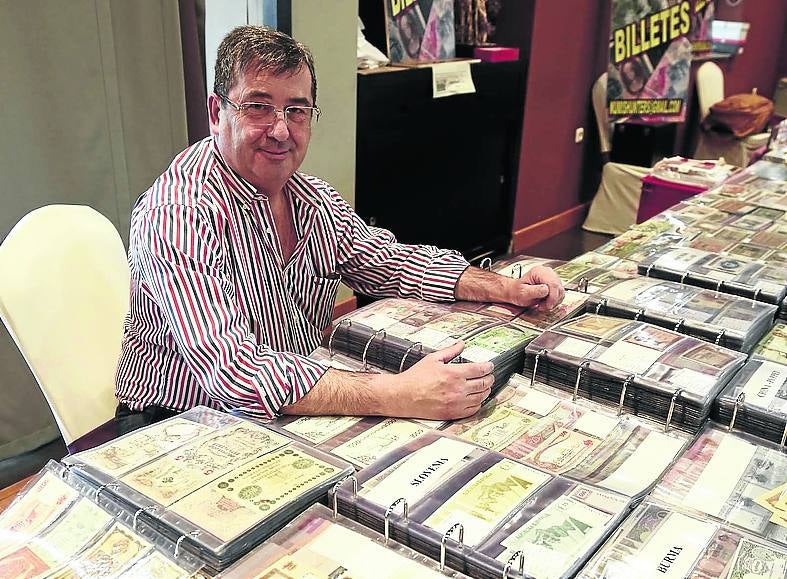 Francisco Cuadrado, en su mesa repleta de billetes del mundo. 