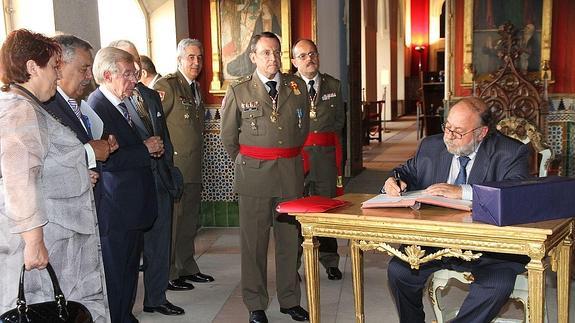 El arquitecto Juan Hernández Ferrero firma en el libro de honor del Alcázar ante los miembros del Patronato tras pronunciar su conferencia.