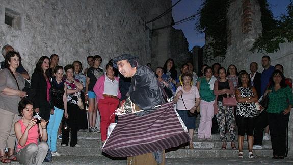 Participantes en una ruta teatralizada nocturna observan al actor. 