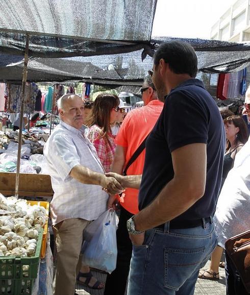 Óscar Puente saluda a uno de los comerciantes del mercadillo.