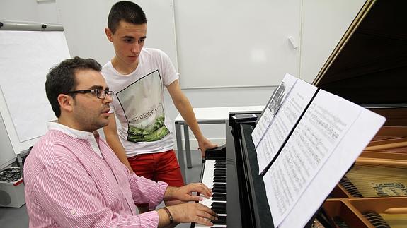 El músico Manuel Tévar, al piano, con uno de los alumnos del curso.