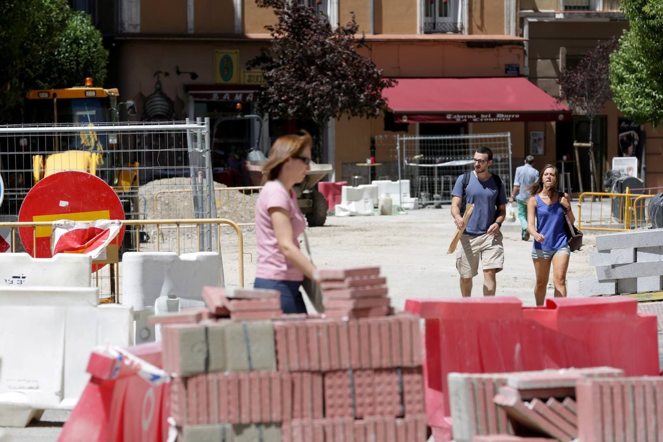 Viandantes atraviesan la calle Esgueva en obras.