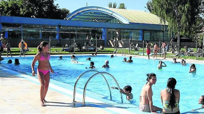 Niños y adultos disfrutan del verano mientras toman un baño en la piscina municipal de Garrido. 