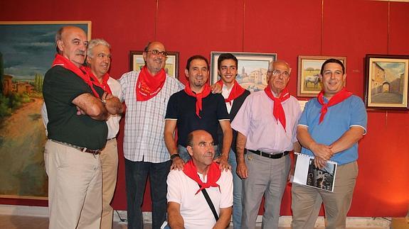Los artistas que participan en la exposciión posan con el pañuelo rojo. 
