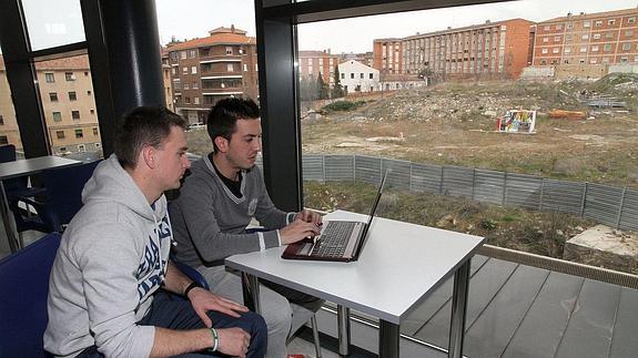 Dos alumnos del campus de la UVA, ante el ventanal desde el que se ve la parcela de la segunda fase.