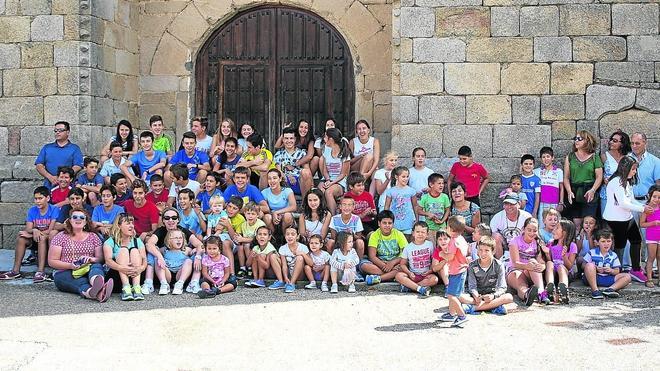 Los niños y jóvenes que participaron en los juegos de la mañana posan junto a algunos de los vecinos organizadores de los mismos. 