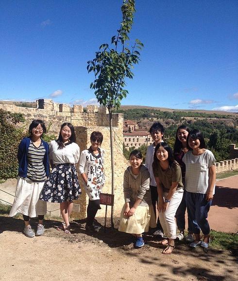 Claudia de Santos y los estudiantes japoneses, con el árbol.