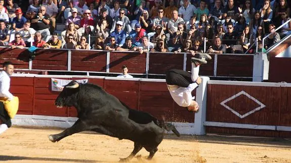 Uno de los concursantes realiza un acrobático recorte ante el toro.