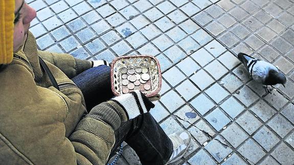 Una mujer pide limosna en la calle.