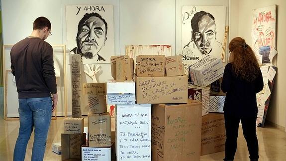 Dos visitantes leen los mensajes de la exposición.