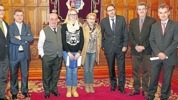 Yanira Gallardo, en el centro, con su abuelo y su madre, junto al alcalde, el concejal Facundo Pelayo y varios dirigentes de Aquona.