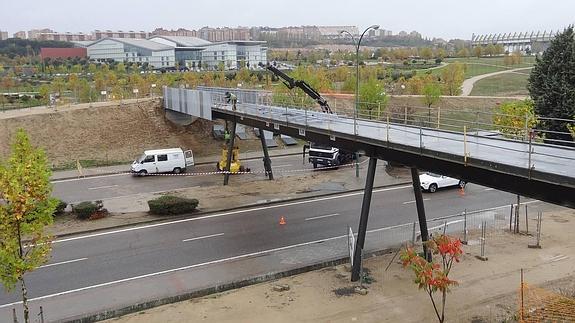 Varios trabajadores colocan las mallas metálicas que cubren los laterales y la parte inferior de la pasarela del cerro de Las Contiendas.