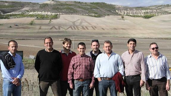 Los agricultores que impulsa la iniciativa en redes sociales. Al fondo, la etiqueta #yacaminos ‘arada’ en la tierra.
