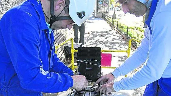 Dos operarios de Telefónica instalan la fibra óptica en la avenida Padre Claret de Segovia. 