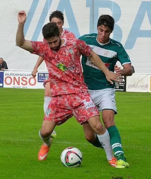 Nestor recibe la presión de un rival del Coruxo. 