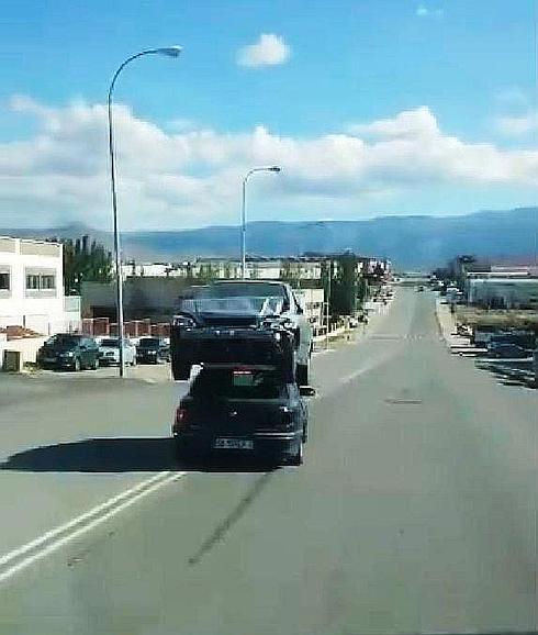 Otro coche transporta otro vehículo sobre el techo en el mismo polígono de Segovia