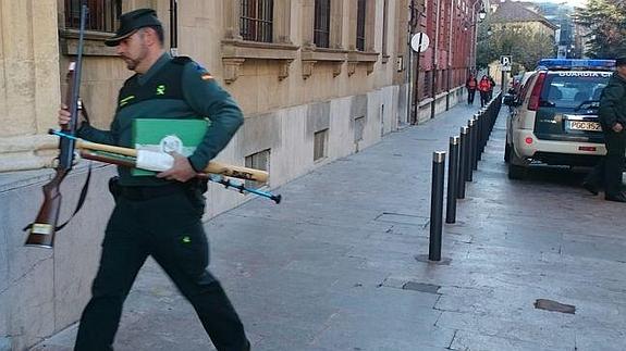 Un agente de la Guardia Civil introduce en la Audiencia  de León varias de las armas incautadas al 'Rambo del Bierzo'.
