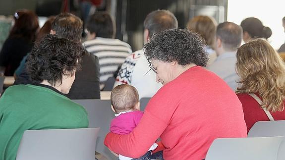 Unas madres juegan con su hija durante la celebración de la jornada.