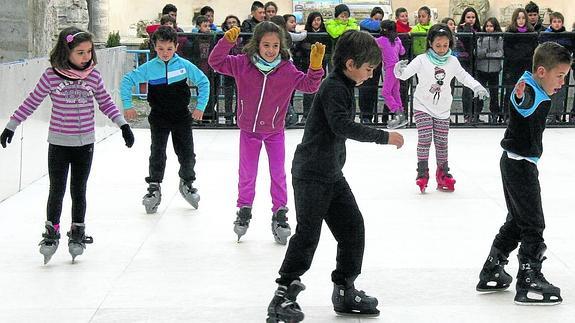 Un grupo de escolares patinan en la pista de hielo ecológica. 