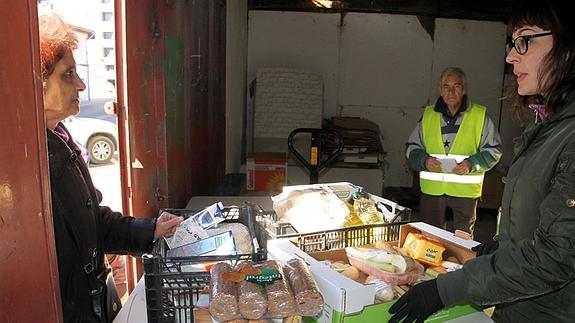 Reparto de alimentos en uno de los almacenes laterales de la plaza de toros.