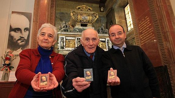 Petra Gómez, Guillermo Herrero y Salvador Ros presentan la publicación ante el sepulcro del santo.